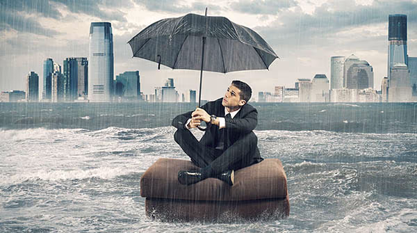 mann-mit-regenschirm-im-regen-vor-skyline-versicherung